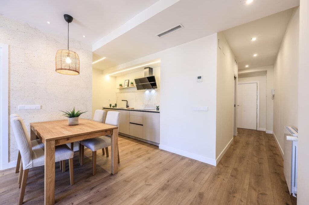 Zona de comedor junto a la cocina abierta de la vivienda reformada en Calle Jordán 8