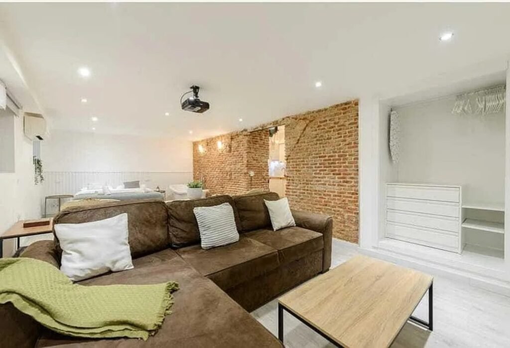 Salón del apartamento reformado en Barbieri 3, con pared de ladrillo visto